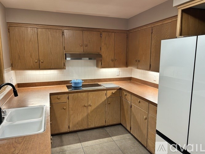 A kitchen with wooden cabinets and a white fridge.