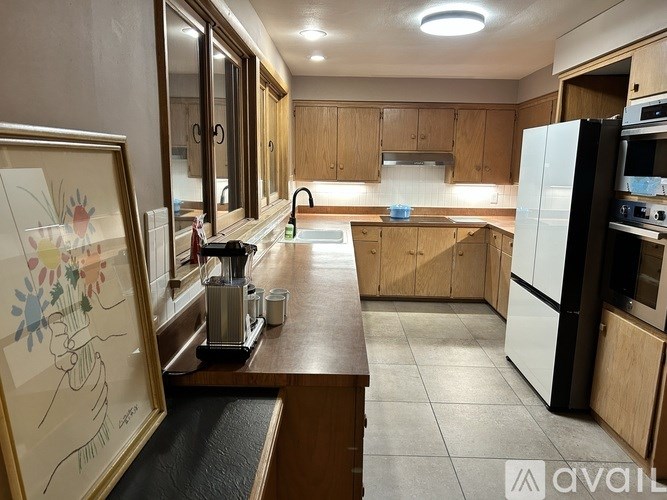 A kitchen with wooden cabinets and a white fridge.