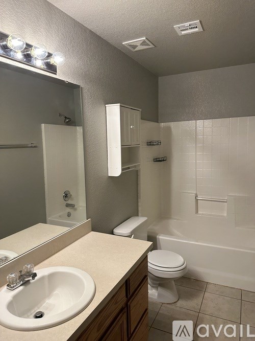 A bathroom with a sink, toilet, and bathtub.