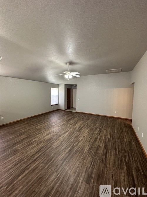 A room with wooden flooring and a ceiling fan.