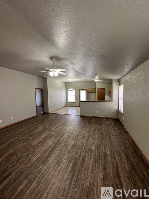 A room with wooden flooring and a ceiling fan.