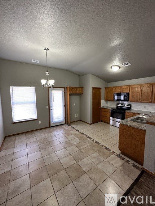 A kitchen with tile flooring and a chandelier.