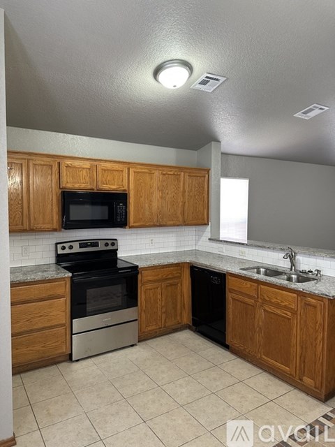 A kitchen with wooden cabinets and a black stove top oven.