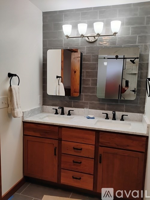 A bathroom with a white counter top and wooden cabinets.