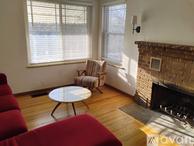 A living room with a fireplace and a red couch.