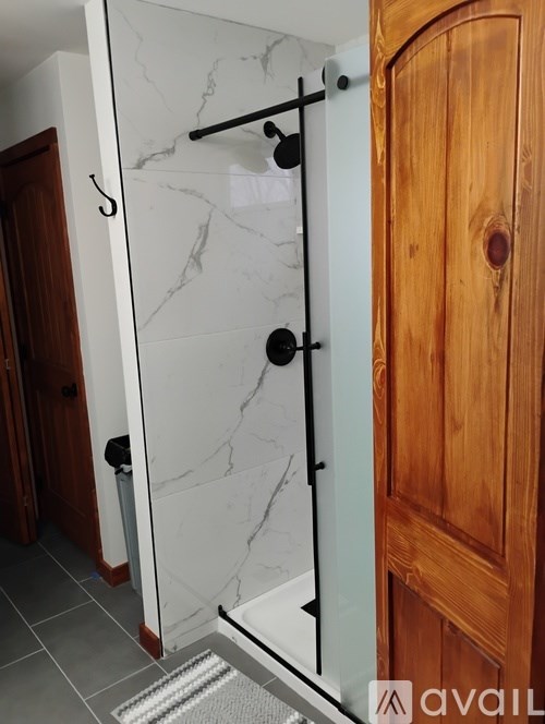 A bathroom with a marble wall and a wooden door.