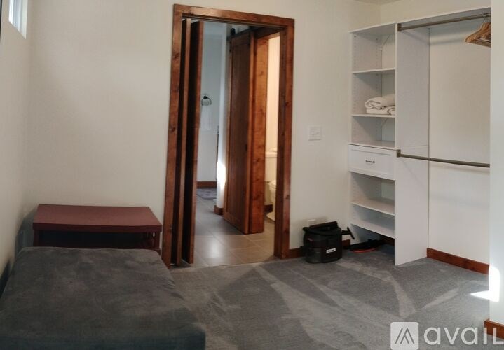 A room with a bed, a wardrobe, and a door.