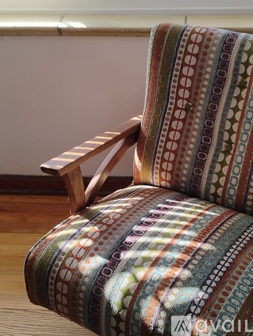 A chair with a colorful patterned cushion is in the foreground.