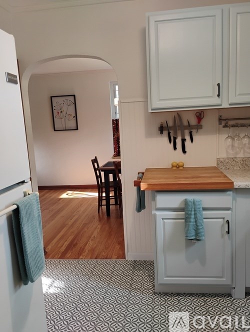 A kitchen with a white fridge and a wooden table.