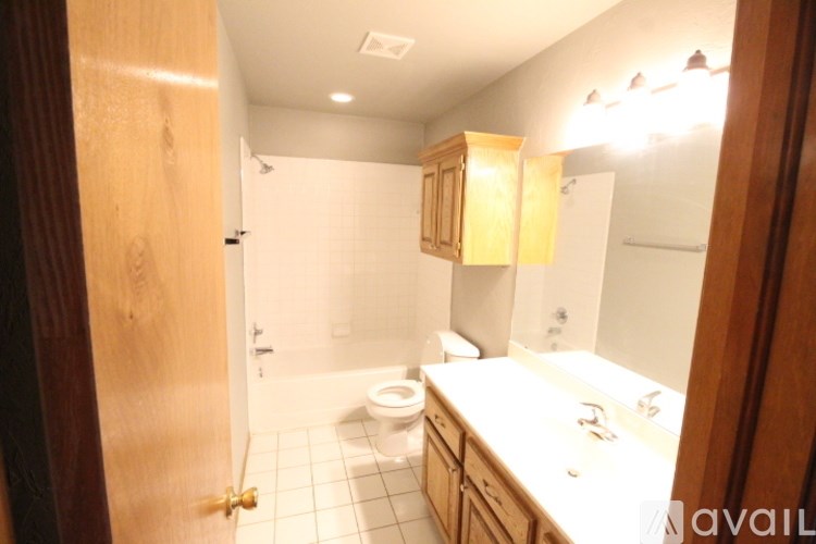 A bathroom with a toilet, sink, and mirror.