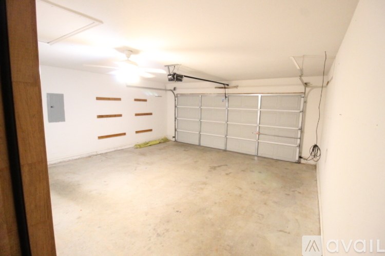 A large empty garage with a white door and a white wall.