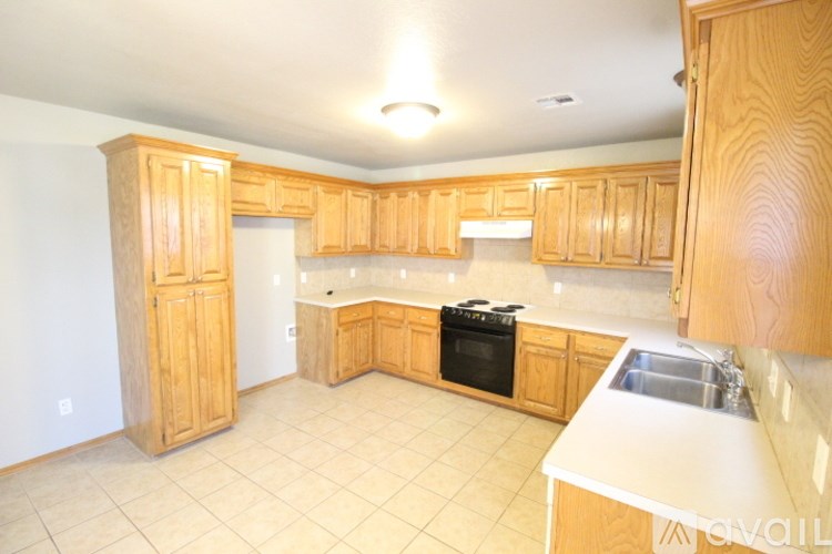 A kitchen with wooden cabinets and a black stove top oven.