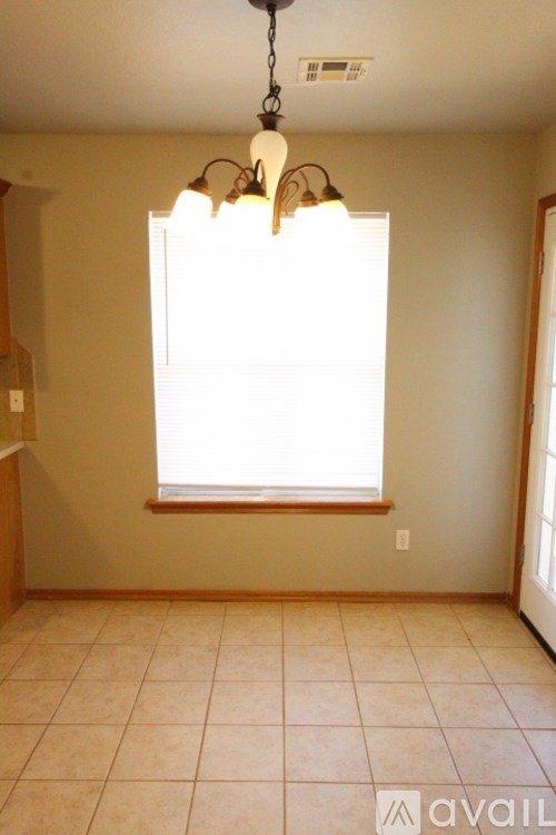 A room with a window and a chandelier.