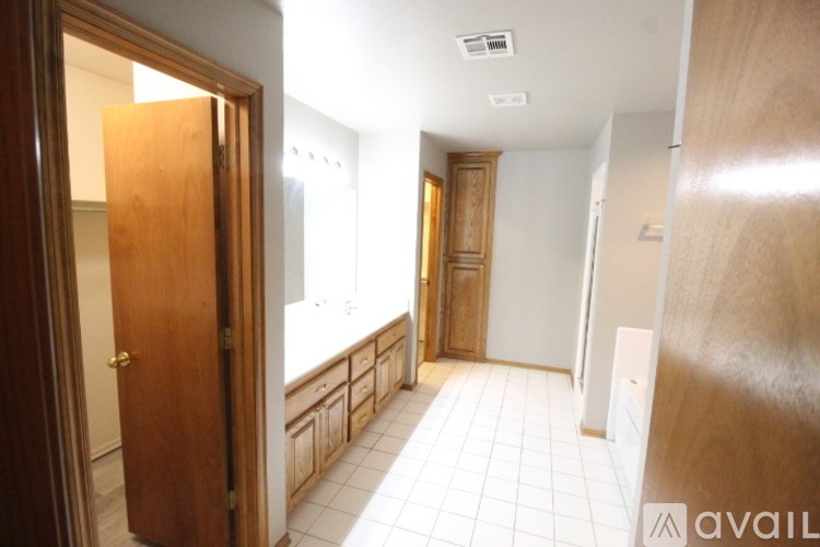 A hallway with a door on the left and a wall on the right.