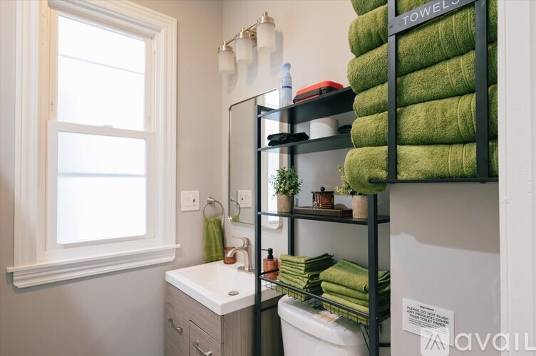 A bathroom with a white sink and a window.