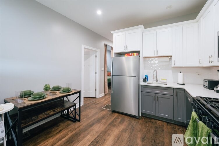 A kitchen with a refrigerator, sink, and cabinets.