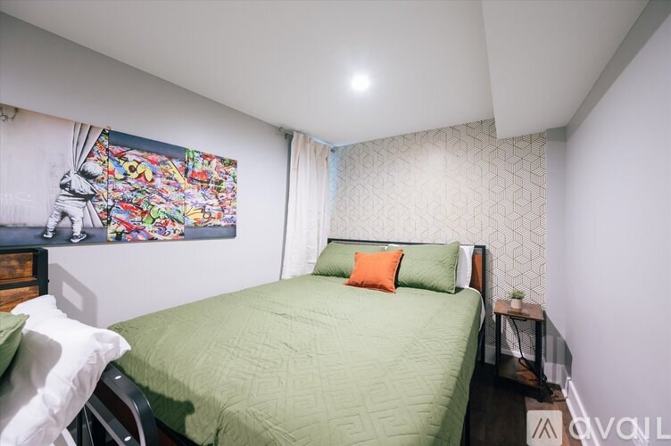 A bedroom with a bed, a nightstand, and a wall hanging.