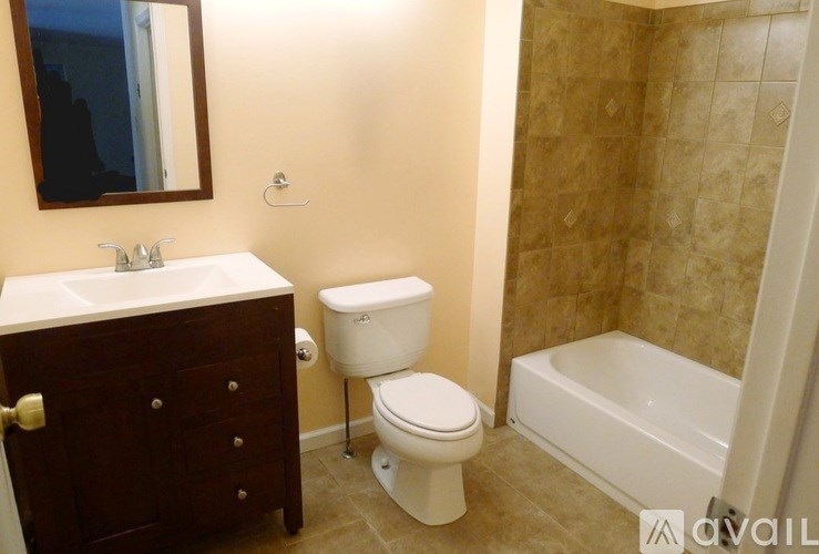 A bathroom with a toilet, sink, and bathtub.