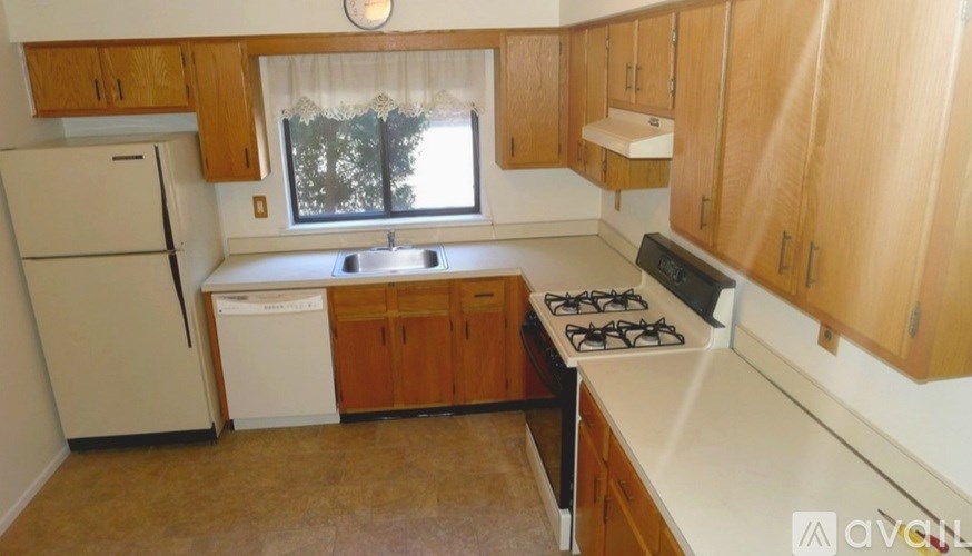 A kitchen with wooden cabinets and a white fridge.
