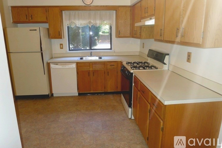 A kitchen with wooden cabinets and a white fridge.