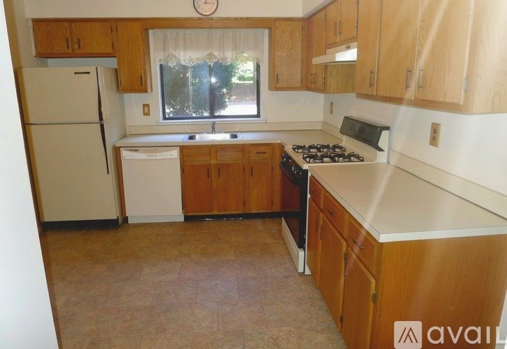 A kitchen with wooden cabinets and a white fridge.