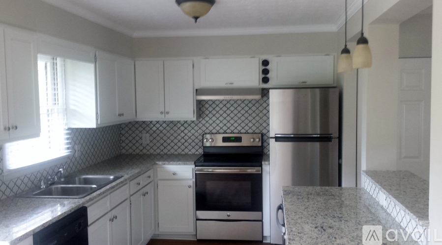 A kitchen with white cabinets and a granite counter top.
