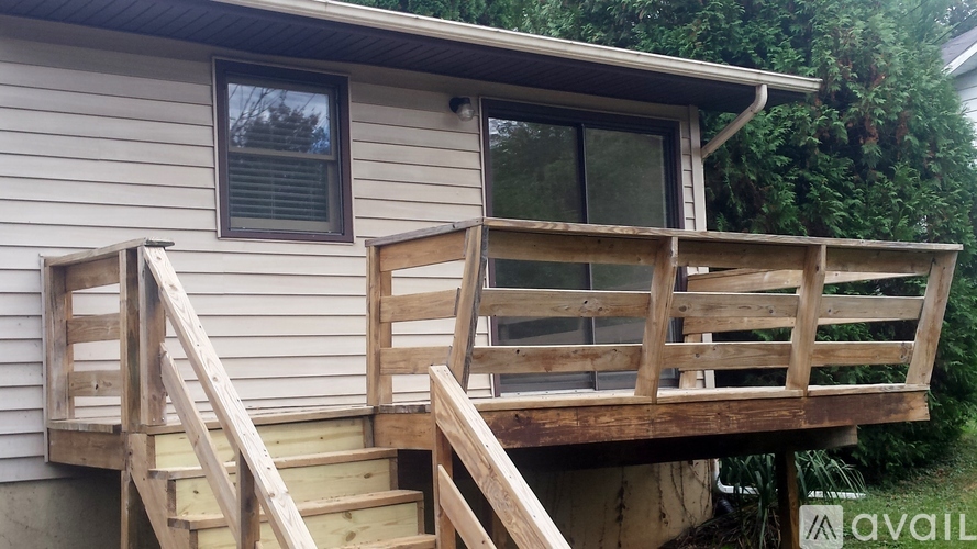 A wooden deck with stairs leading to a house.
