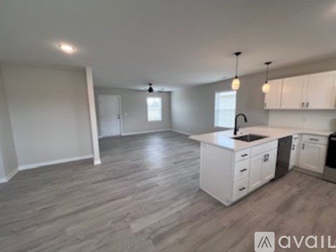 A kitchen with white cabinets and a wooden floor.