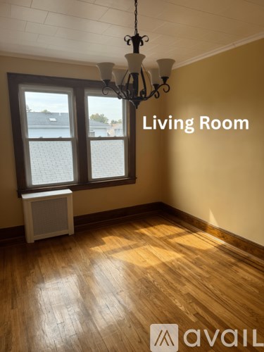 A living room with a window and a chandelier.