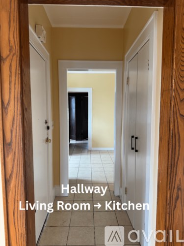 A hallway leading from a living room to a kitchen.