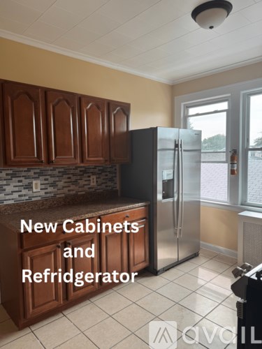 A kitchen with new cabinets and a refrigerator.
