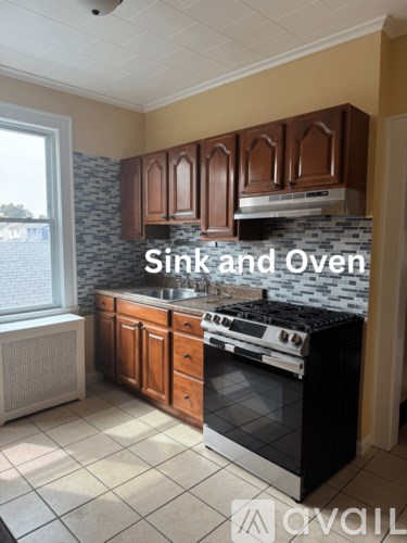 A kitchen with a sink, oven, and cabinets.