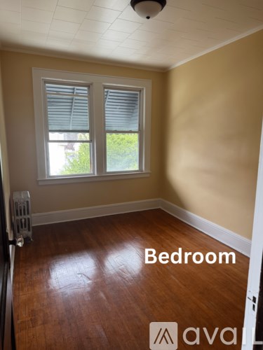 A room with a window and wooden floors.