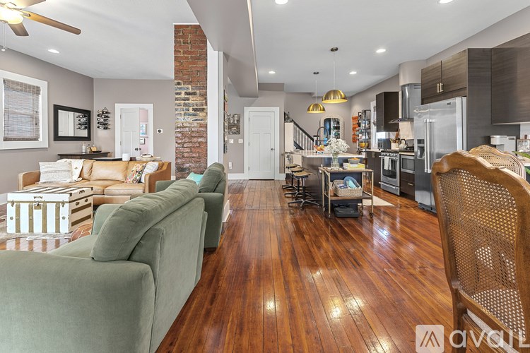 A living room with a green couch and a wooden floor.