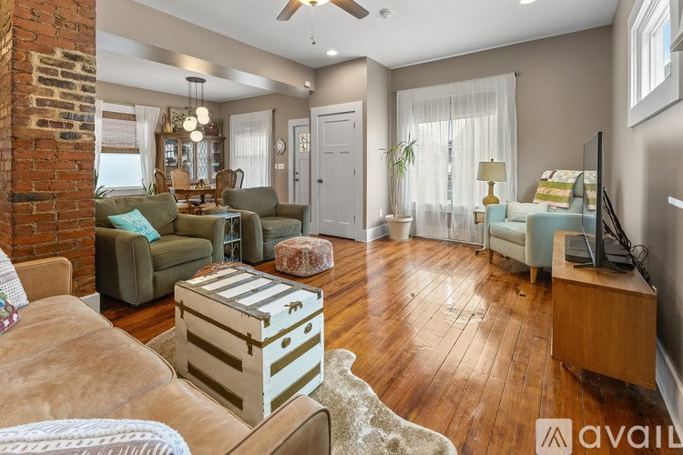 A living room with a brick wall and wooden floors.