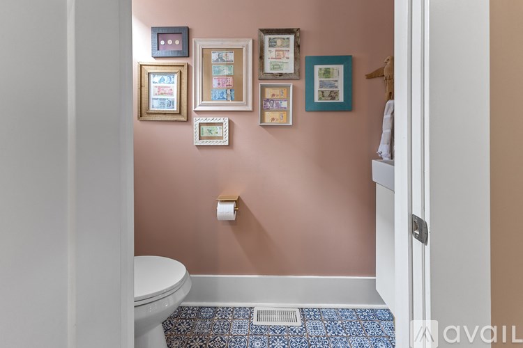 A bathroom with a toilet and pictures on the wall.