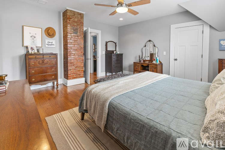 A bedroom with a large bed and a dresser.