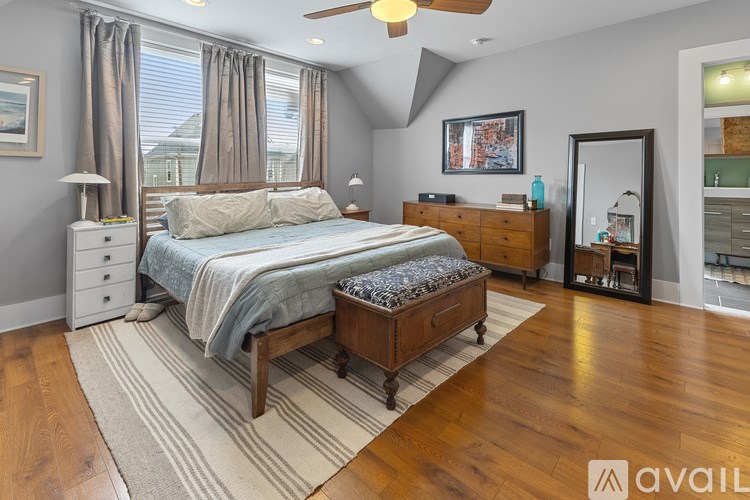 A bedroom with a bed, dresser, and mirror.