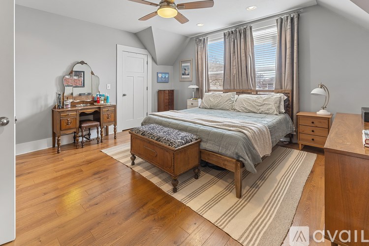 A bedroom with a bed, desk, and chair.