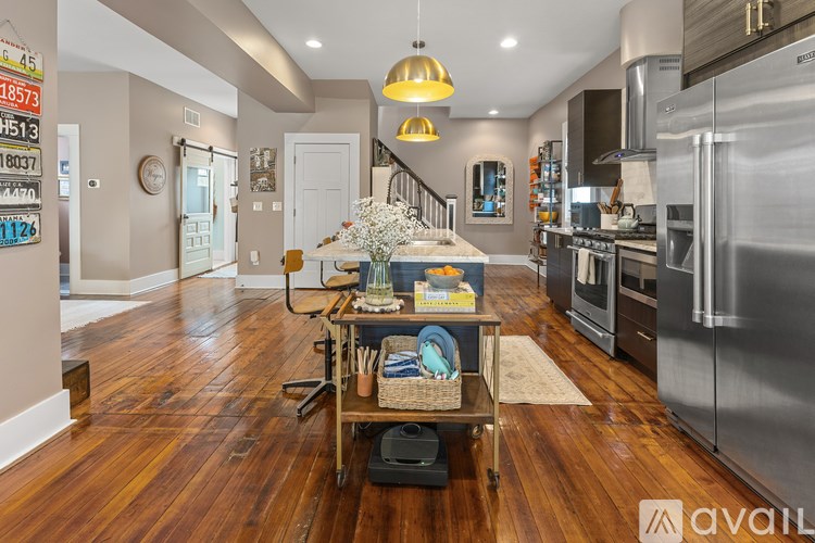 A kitchen with wooden floors and stainless steel appliances.
