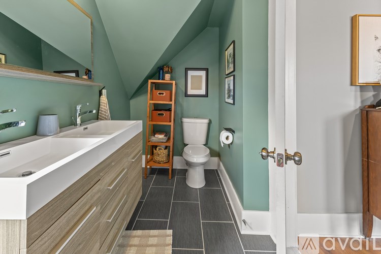 A bathroom with a green wall and a white door.