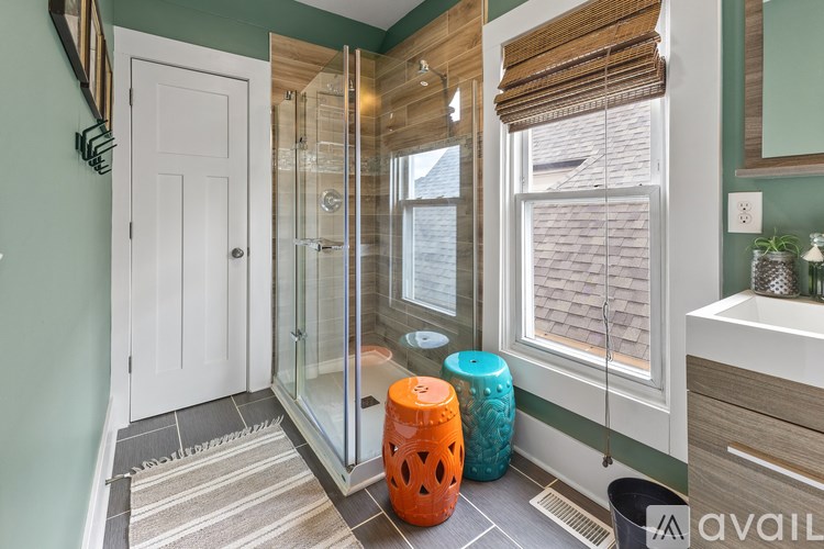 A bathroom with a glass shower door and a white door.