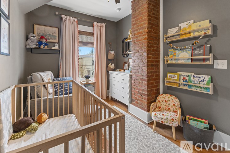A baby's room with a crib, dresser, and a window with curtains.