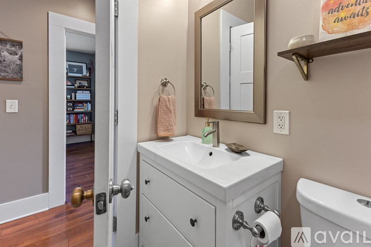 A bathroom with a white sink and a mirror above it.