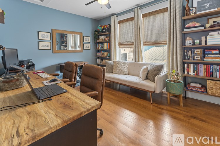A room with a wooden desk and a couch.