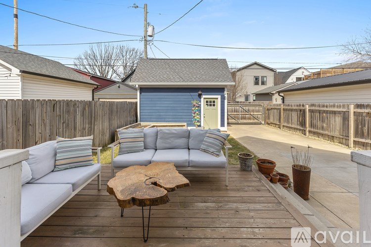 A wooden deck with a white sofa and a wooden table.