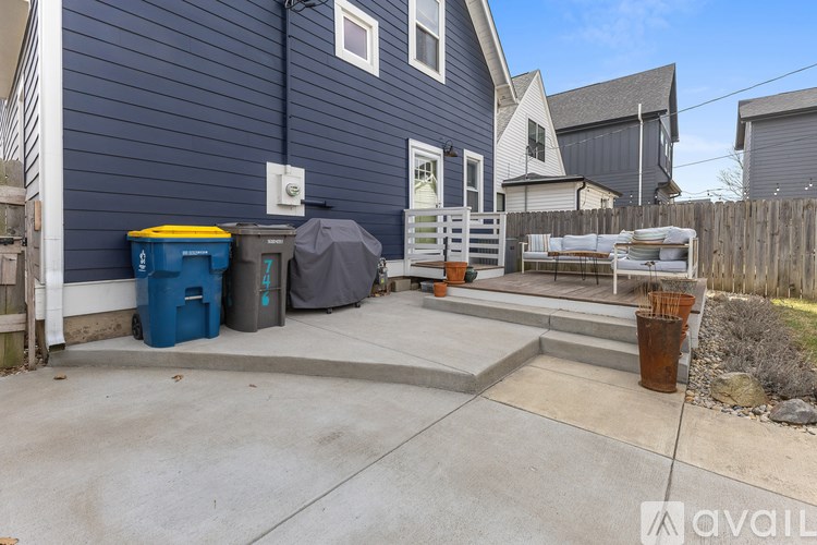 A blue house with a grey tarp on the patio.