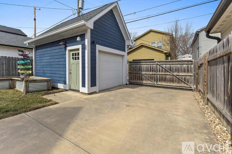 A blue house with a white garage door is in the foreground.