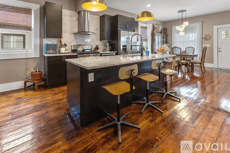 A kitchen with a large island and wooden floors.