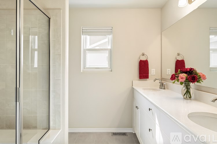 A bathroom with a white sink and a glass shower door.